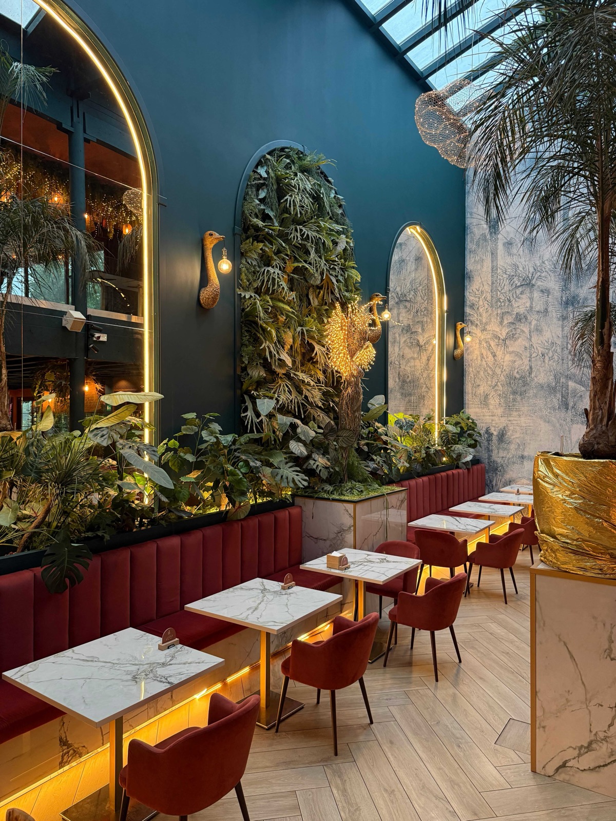 L’area lounge di Eden con divanetti rossi e vegetazione